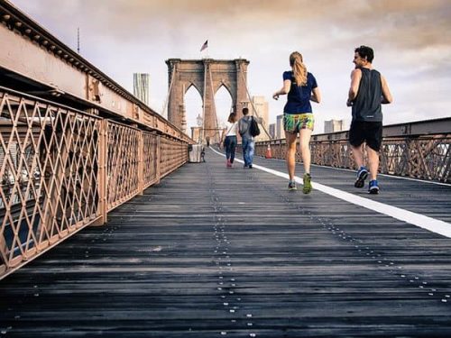 two people running over a bridge