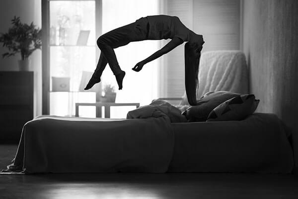 image of a woman floating above the bed