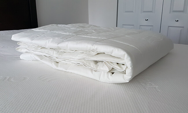 the slumbercloud comforter and mattress pad on a bed