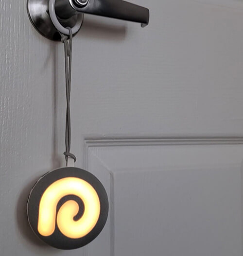 dreamegg d11 white noise machine hanging on a door handle