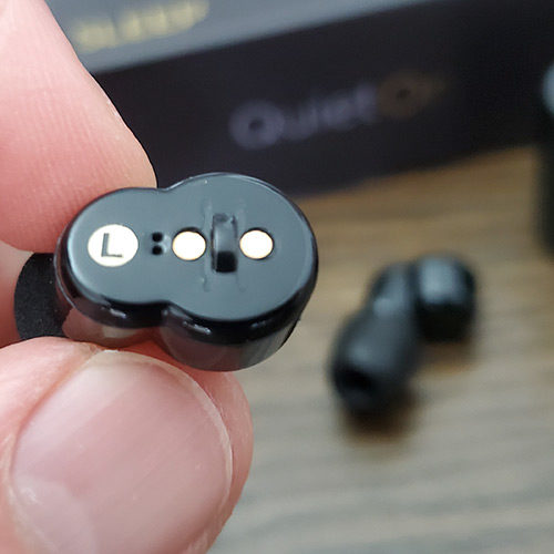 close up photo of the button on the  left quieton earbud